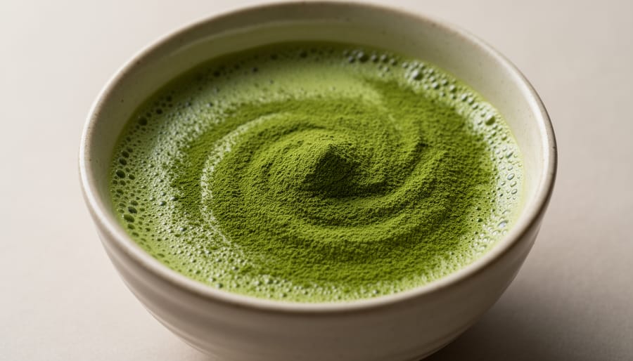 Close-up of vibrant green matcha powder in a ceramic bowl with a bamboo whisk nearby